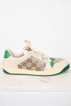 A Gucci low-top sneaker in beige suede and GG Supreme canvas, embellished with rhinestones on the toe box, featuring green heel and outsole accents.