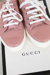 Pink Gucci sneakers with white laces on a Gucci box.