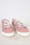 Pair of pink sneakers with white laces on a light background