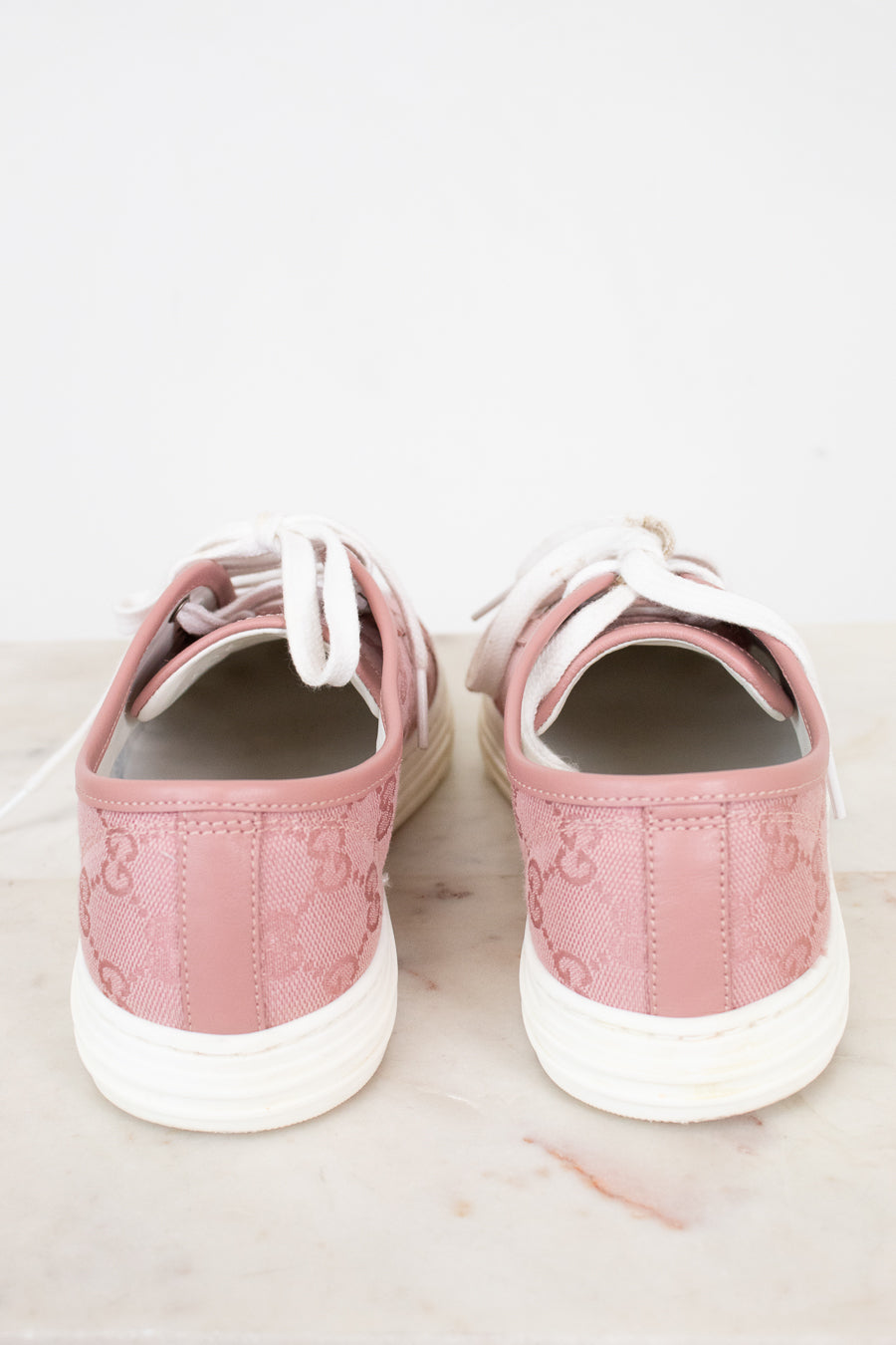 Pair of pink sneakers on a light marble surface