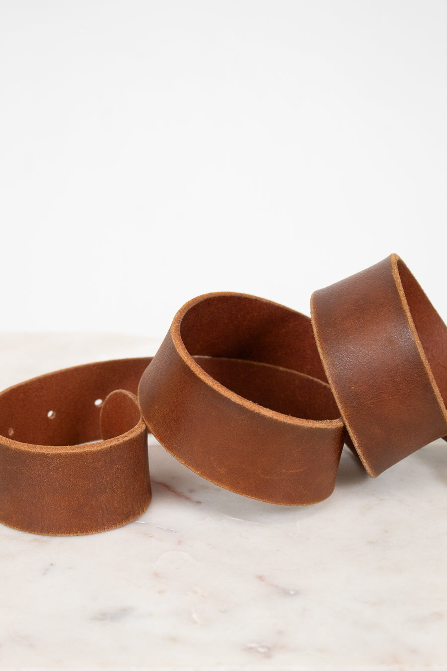 Brown leather belt on a marble surface