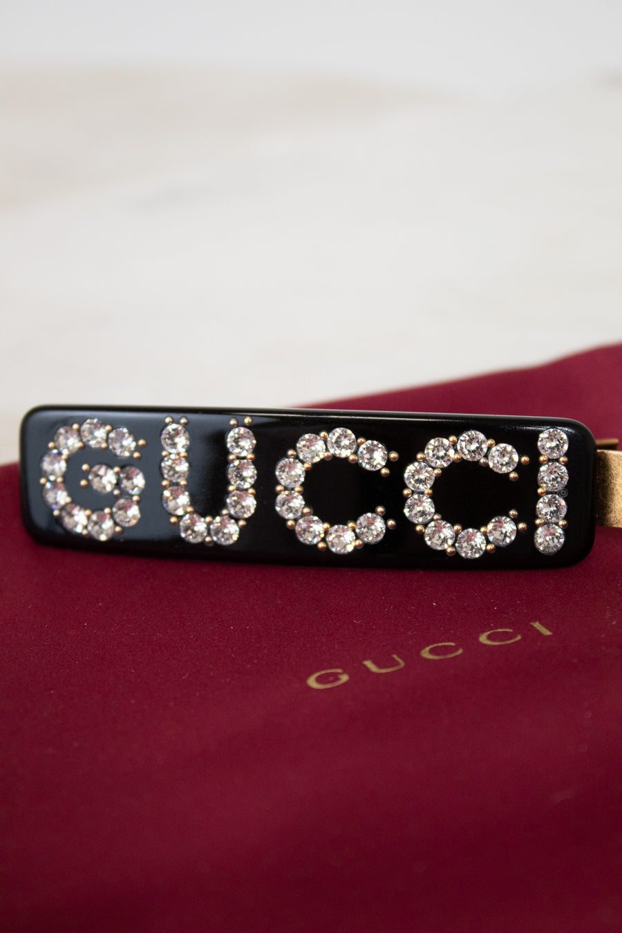 Gucci hair clip with rhinestones on a red background