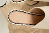 Close-up of Gucci sandals with a beige background