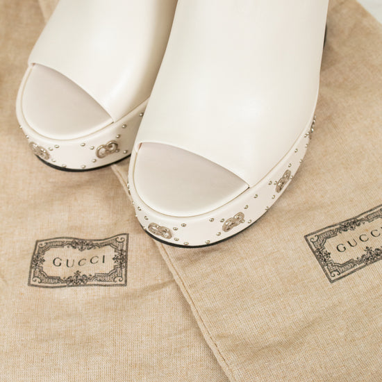 White open-toe shoes on Gucci branded dust bags