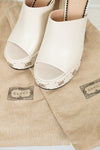 White open-toe shoes on Gucci branded dust bags