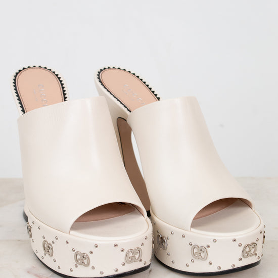 White platform sandals with decorative studs on a light background