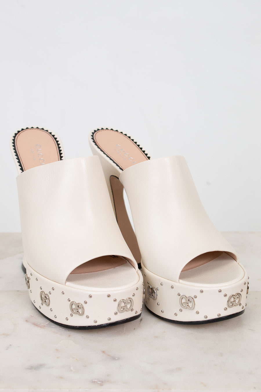 White platform sandals with decorative studs on a light background