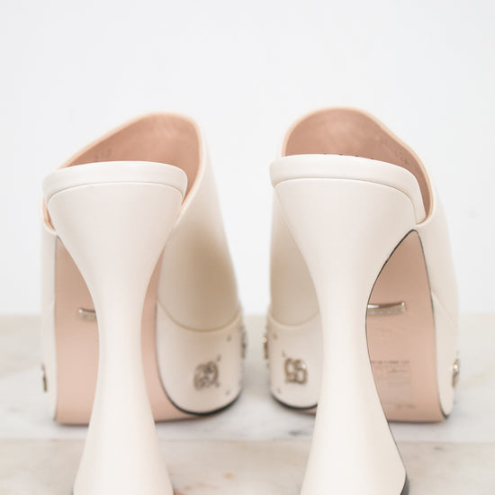 Pair of white high-heeled platform shoes on a light background