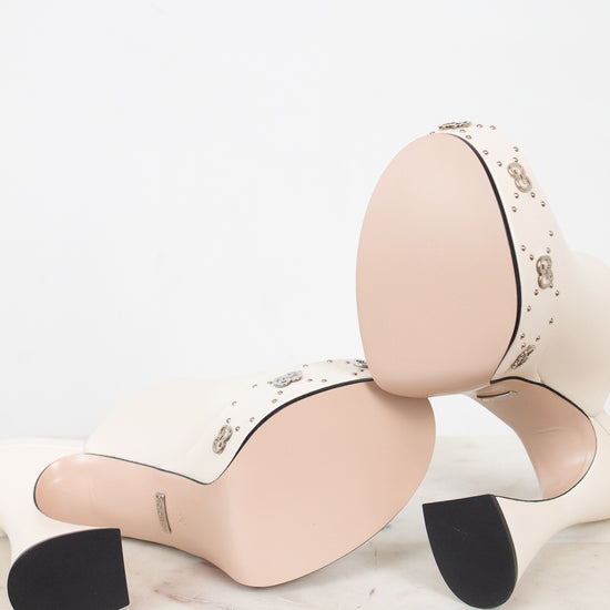 Pair of beige platform high-heeled shoes with pristine soles on a white background