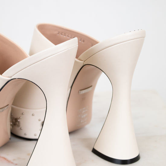 White platform high-heeled shoes with black soles on a light background