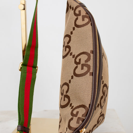 Gucci waist bag with green and red strap on a light gray background
