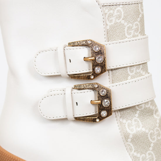 Two gold buckles on cream boot with white background