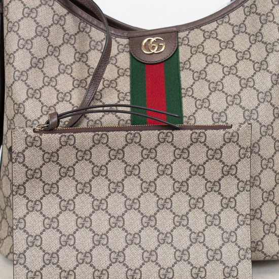 Gucci GG Supreme canvas shoulder bag with a matching zippered pouch, featuring the signature brown GG monogram, green and red web stripe, and brown leather trim.