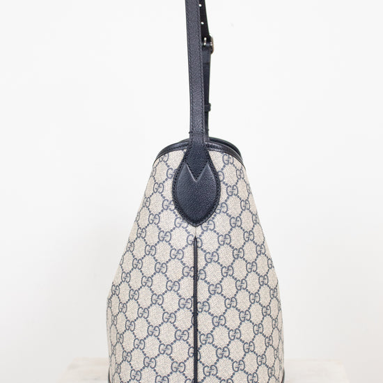 Close-up of side view of tote bag showing a GG monogrammed print against a plain background 