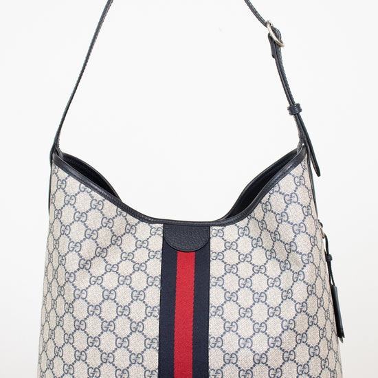 Back view of a monogrammed tote bag showing red and navy center stripe against a plain background