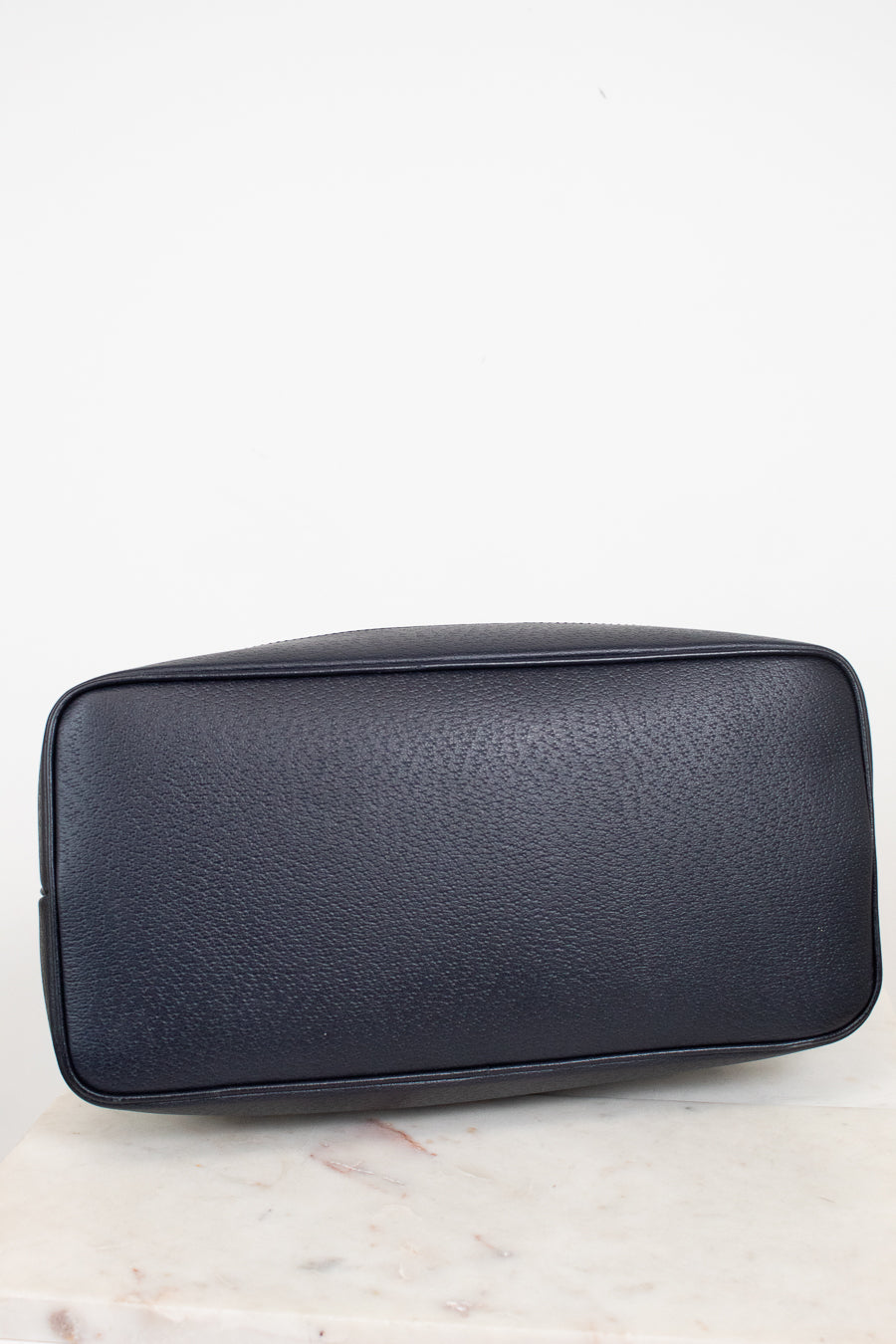 View of bottom exterior navy leather of tote bag