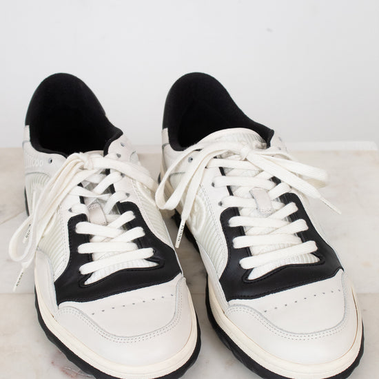 White and navy sneakers set against  plain marble surface