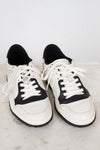 White and navy sneakers set against  plain marble surface