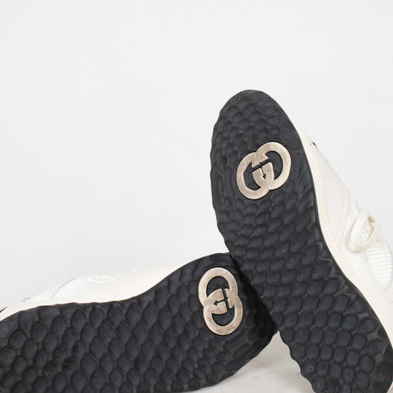 Bottom view of exterior soles showing minimal wear to navy and white 'GG' logo sneakers