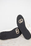Bottom view of exterior soles showing minimal wear to navy and white 'GG' logo sneakers