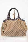 Beige handbag with brown Gucci monogram print on a white background