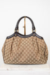 Beige handbag with brown Gucci monogram with brown handles on a white background
