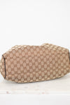 Bottom view of beige handbag with Gucci monogram pattern on a white background