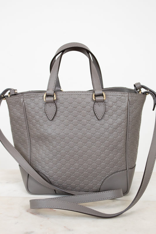 Gray quilted handbag with a shoulder strap on a light background