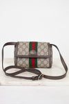 A Gucci monogram coated canvas crossbody bag with a brown leather strap and trim, featuring the signature green and red web stripe down the center and a gold-tone interlocking G logo on the front flap.