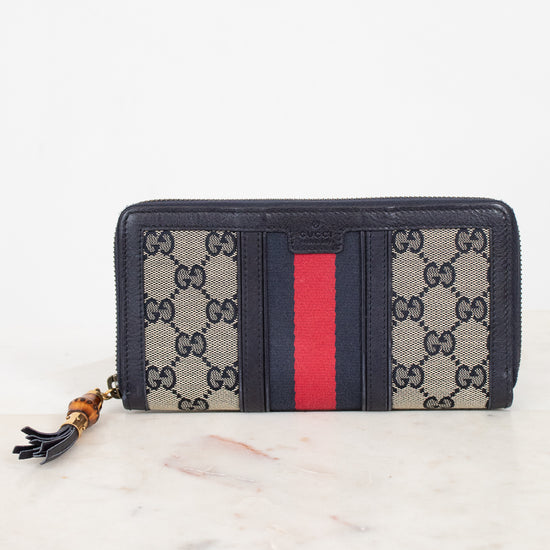 Navy and monogrammed zip around wallet with red and navy striped center detail with gold and bamboo zipper 