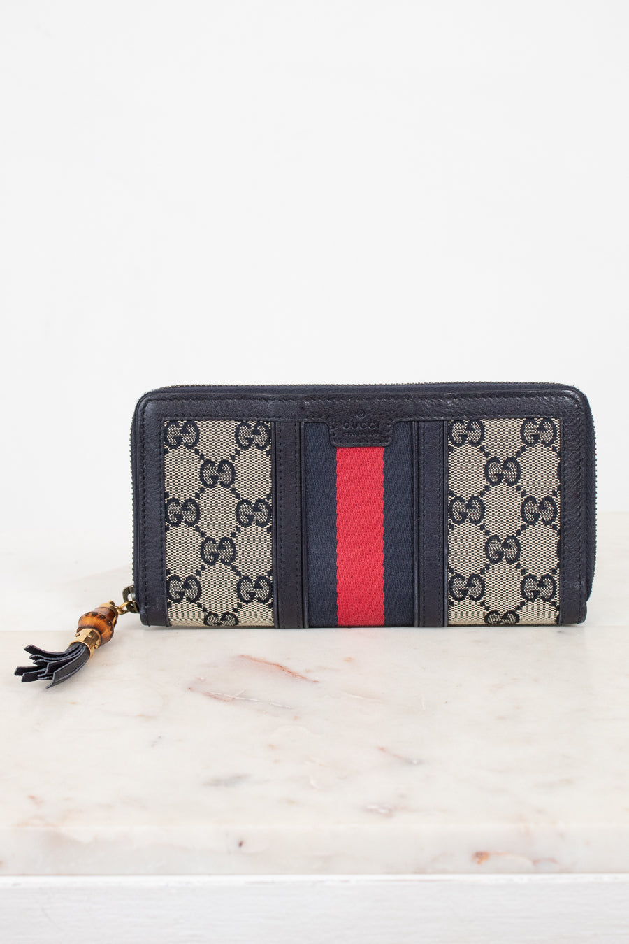 Navy and monogrammed zip around wallet with red and navy striped center detail with gold and bamboo zipper 