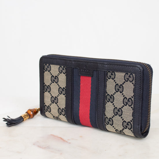 Navy and monogrammed zip around wallet with red and navy striped center detail with gold and bamboo zipper detail