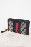 Navy and monogrammed zip around wallet with red and navy striped center detail with gold and bamboo zipper detail