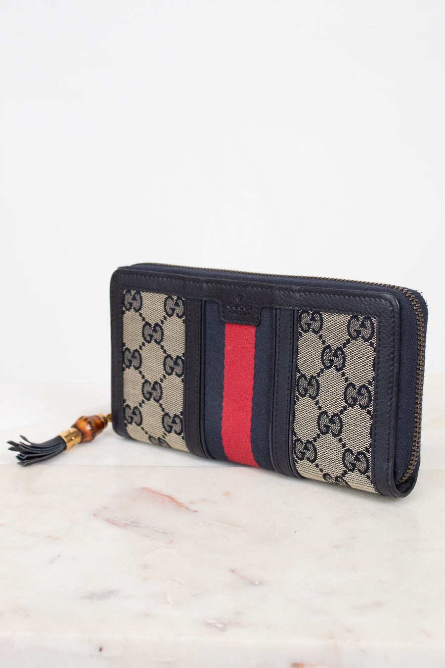 Navy and monogrammed zip around wallet with red and navy striped center detail with gold and bamboo zipper detail