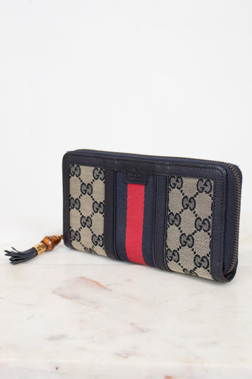 Navy and monogrammed zip around wallet with red and navy striped center detail with gold and bamboo zipper detail