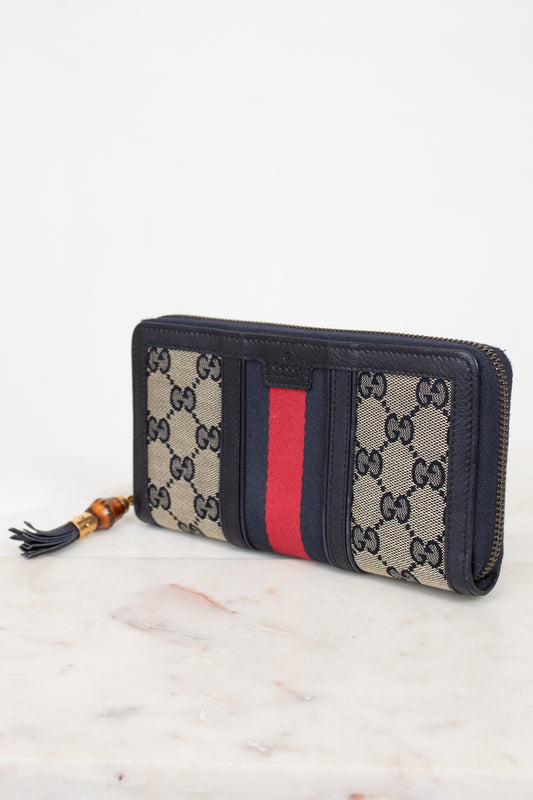 Navy and monogrammed zip around wallet with red and navy striped center detail with gold and bamboo zipper detail