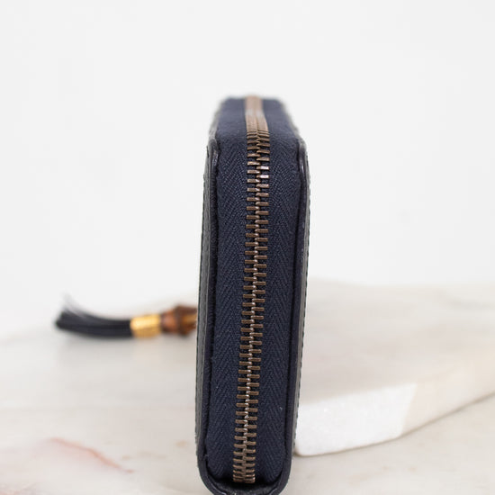 Close-up of zipper edge of wallet laying against a plain background