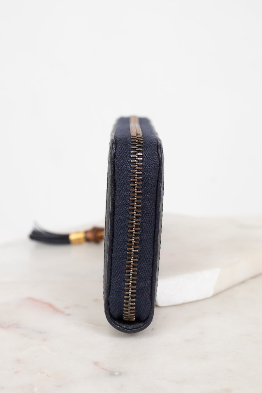 Close-up of zipper edge of wallet laying against a plain background