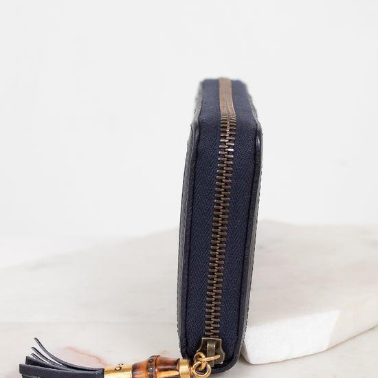 Close-up of side view of wallet showing zipper with gold and bamboo details