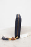 Close-up of side view of wallet showing zipper with gold and bamboo details