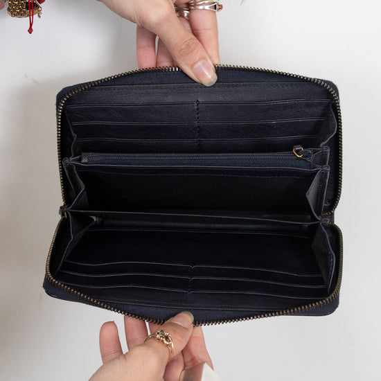 Hands holding open wallet showing many card slots, inserts, and interior zipper detail