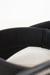 Close-up of a black leather belt with visible stitching on a white background