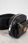 Black leather belt bag with gold clasp on a marble surface