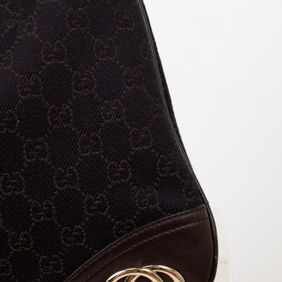 Gucci logo on brown purse with white background 