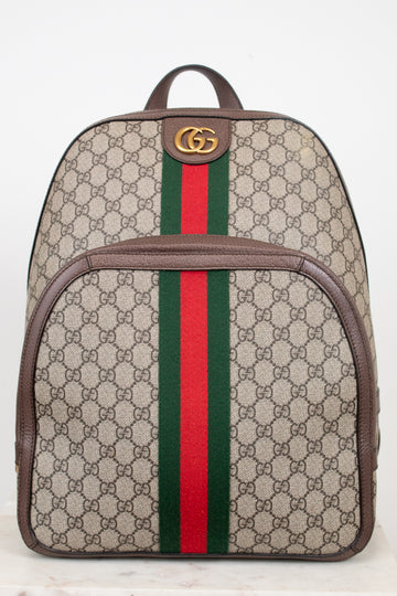 Gucci GG Supreme coated canvas backpack with brown leather trim, a green and red web stripe down the center, and a gold-tone GG logo on the front.