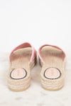 A pair of Gucci espadrille sandals with pink straps and natural jute-wrapped soles, photographed from the back on a light marble surface.