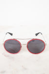 Round sunglasses with red frame and black lenses on a white background