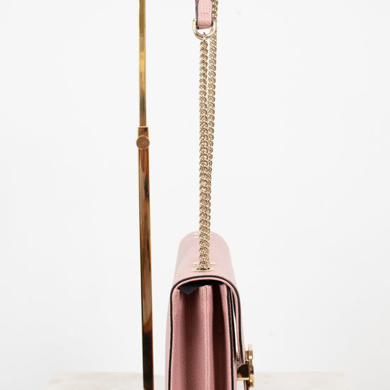Side profile of pink handbag with a chain strap on a white background