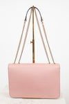 Pink handbag with gold chain strap on a white background