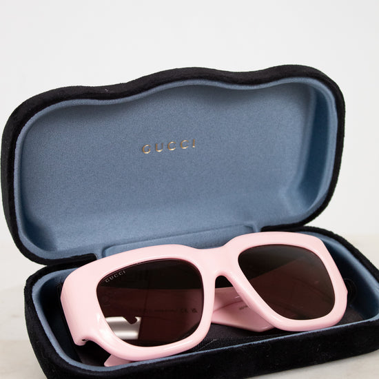 Pink sunglasses in a Gucci case on a light background